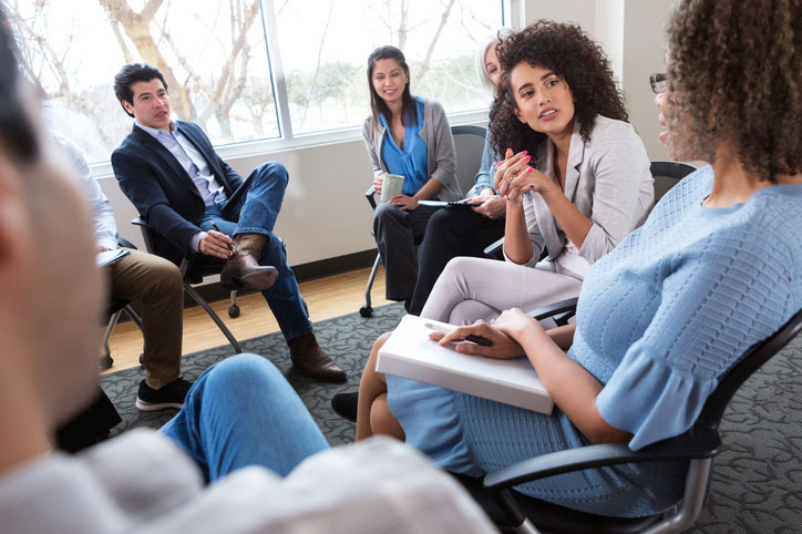 mid-aged social worker talking with group