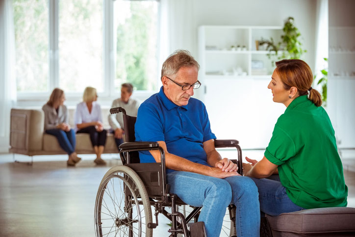 talking with older man in wheelchair