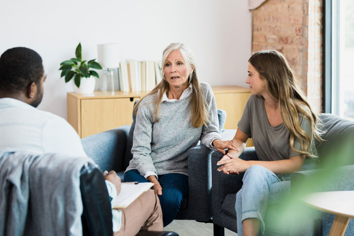 older social worker talking with couple