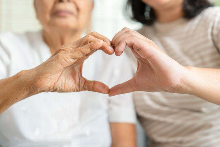 heart hands with social worker and older woman