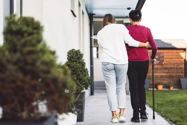 walking patient down sidewalk