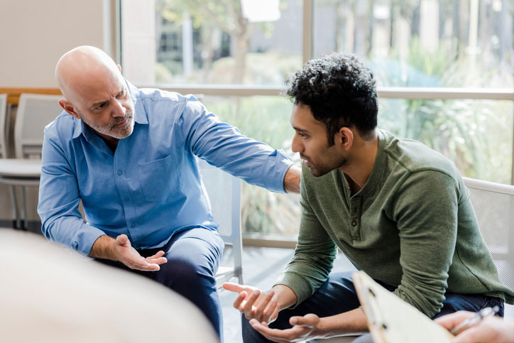 older social worker talking with young man