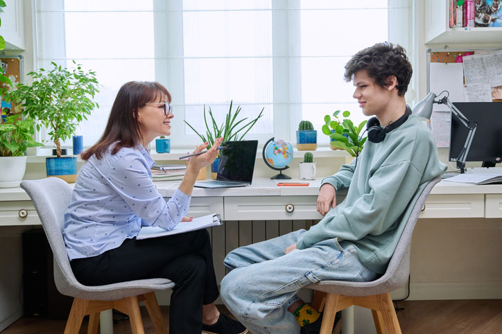 school social worker in office with teen