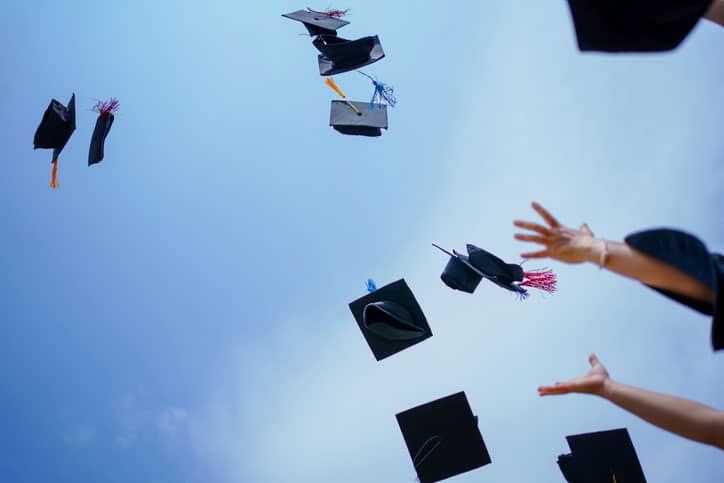 grad caps flying through the air