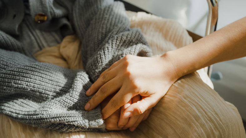 hospice worker holding hands of patient