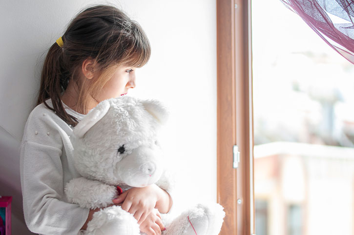 sad girl hugging teddy bear