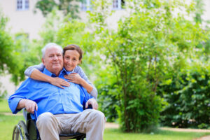 hugging elderly man in wheelchair